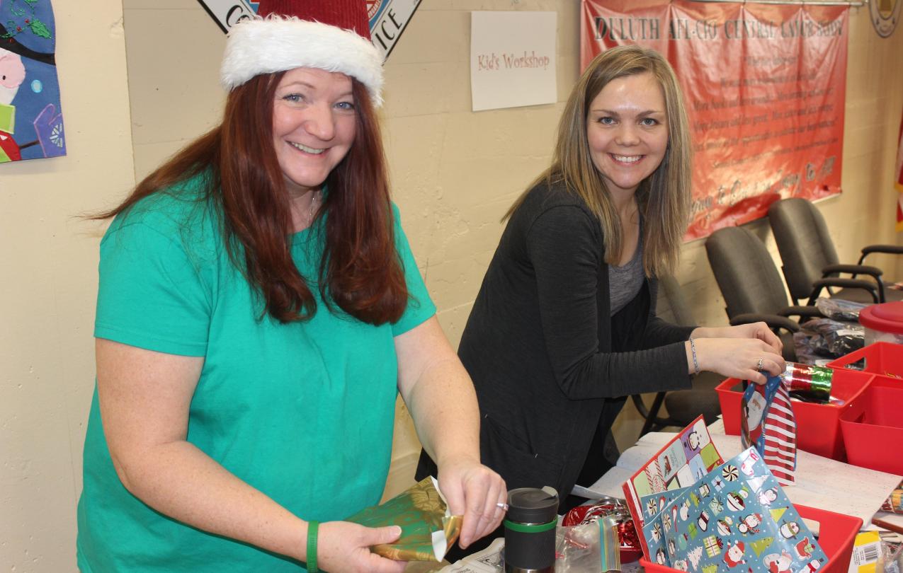 Christina St. Germaine, from Local 1092, helps Local 3558's Rachel Loeffler-Kemp prepare gifts for families at the AFL-CIO Community Services Program's annual kid's holiday party